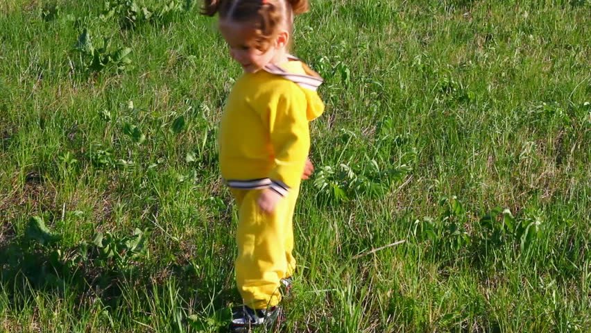 little girl playing with ball on meadow