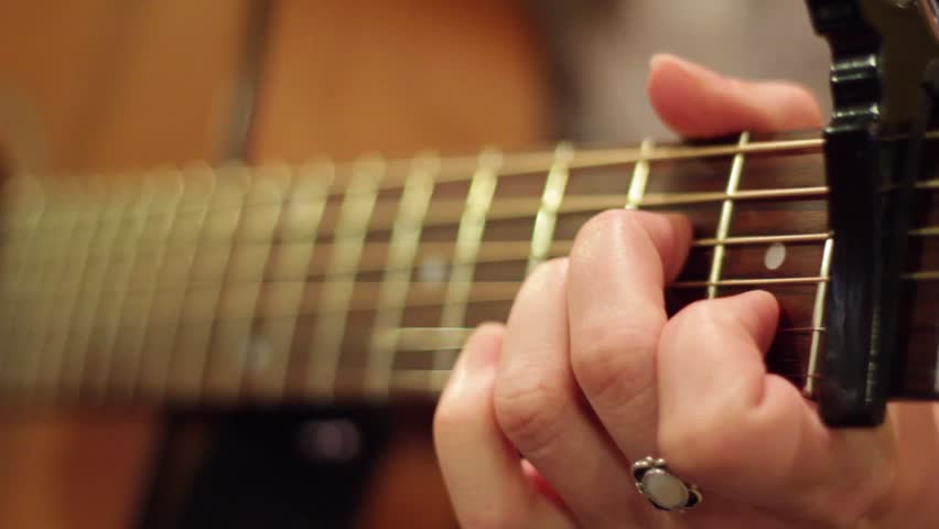 A girl playing the guitar in a studio setting