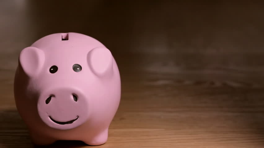 Woman drops quarters into smiling pink piggy bank