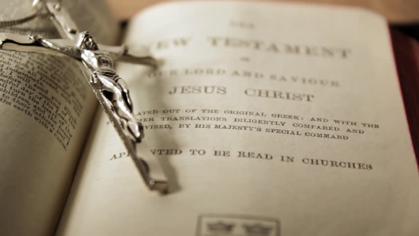 tracking shot around crucifix laying on bible