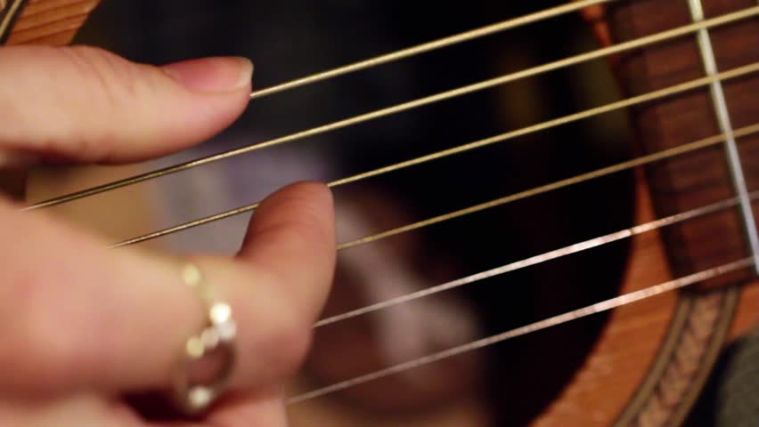 Macro shot of finger picking the guitar