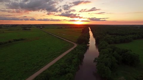 Aerial video of the countryside in Iowa. Farms at sunset. Freeway.