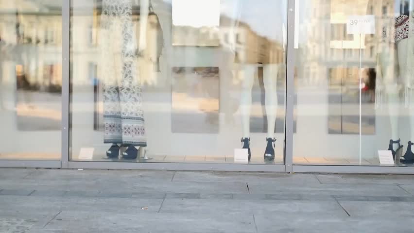 Two girls meet after shopping. Shop window background