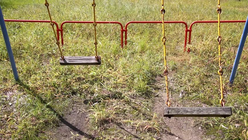 Old rusty swings on an empty playground