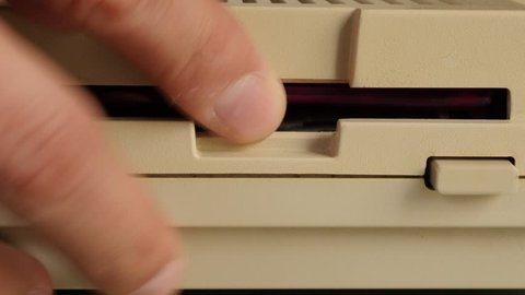 Inserting 3.5 inch floppy disk in retro personal computer 4K 2160p 30fps UltraHD video - Retro diskette insert in old computer disk drive 4K 3840X2160 UHD footage