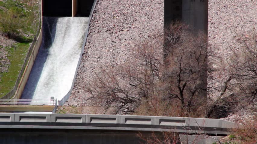 A dam's spillway is full from the spring runoff.