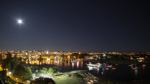 Time lapse of boats traffic at False Creek with moon rising above. Taken in English Bay in downtown Vancouver, British Columbia, Canada