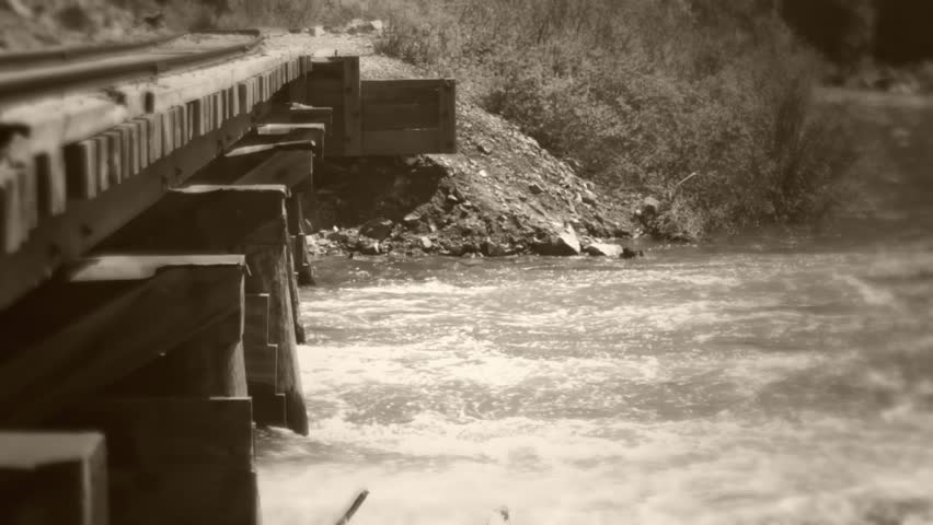 Old train bridge spanning a swollen river from the spring runoff