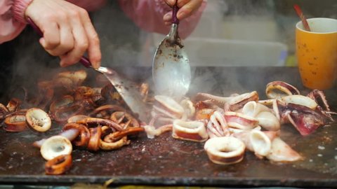 Video of Teppanyaki cook cutting the squid, cuttlefish with sauce on hot pan plate