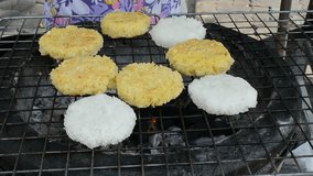 Grill sticky rice cover with egg fried on charcoal barbecue sieve with hand cooking in Thai outdoor market restaurant. It's an Asian Thai native cuisine food in 1920 x 1080 HD video quality.
