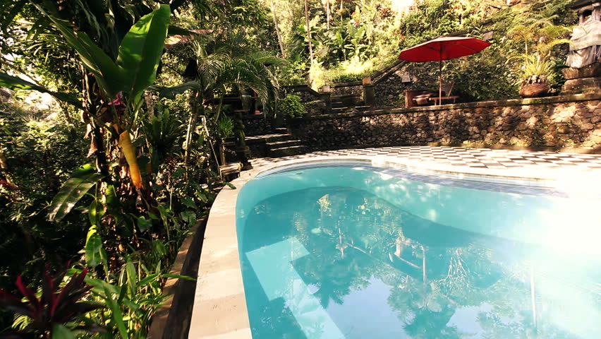 Old stone constructions and exotic plants surrounding a beautiful pool with