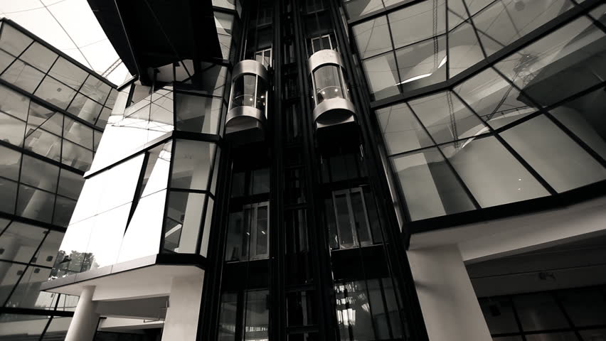 Elevators in futuristic lobby moving up and down in modern architecture