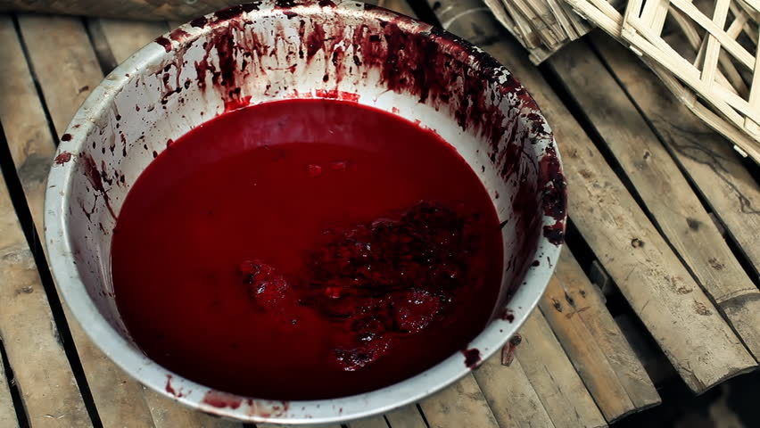 A cup with blood from fresh meat is shaking to the actions of people preparing