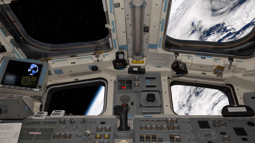 View of the space shuttle cockpit orbiting earth. 