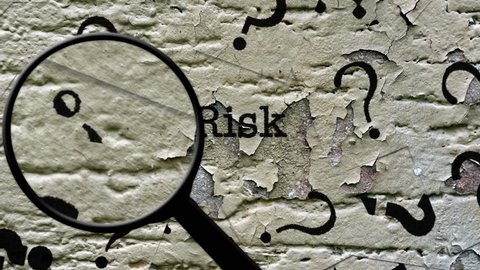 Magnifying glass on risk text 