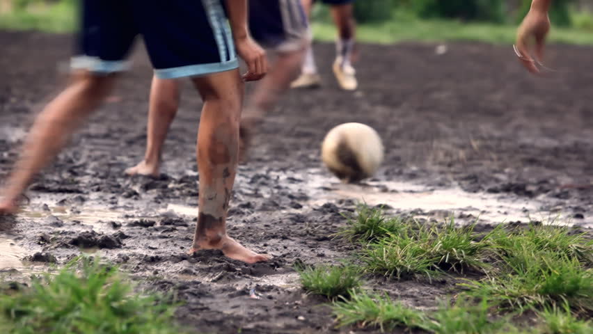 A gang of bar feet kids playing soccer on a muddy field. Serial of slow motion shots with depth of field effects. Action loaded details of running legs and goal shots. [b]HD1080 | 30fps[/b] Royalty-Free Stock Footage #1191613