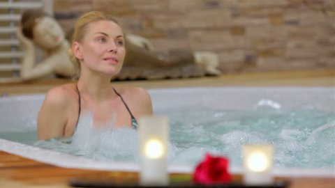Spa resort jacuzzi hot tub woman. Happy woman relaxing in jacuzzi. Woman in spa salon.