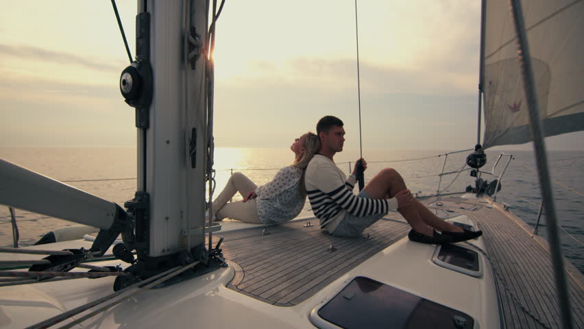 Young couple relaxing on a yacht in the sea at sunset. Shot on RED Cinema Camera in 4K (UHD).