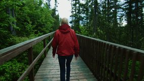 Young Woman Walking on a Boardwalk during a rainy day of Summer in Canada, Quebec.