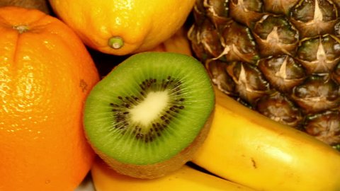 Ripe tropical fruit (healthy food)  – pineapple, kiwi, orange, coconuts, lemon, bananas rotating, front shot, extreme close up, loop (ultra hd 3840x2160) स्टॉक व्हिडिओ