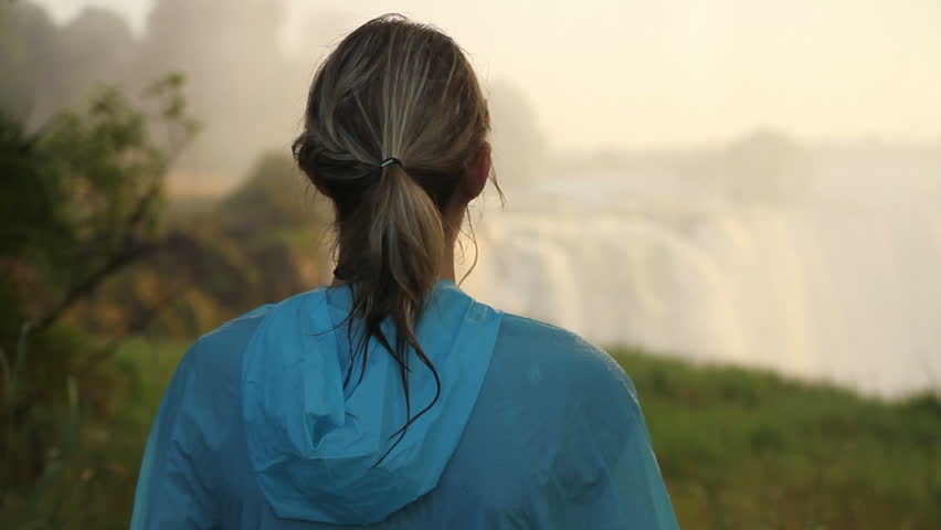 Girl watches Victoria Falls at Sunrise