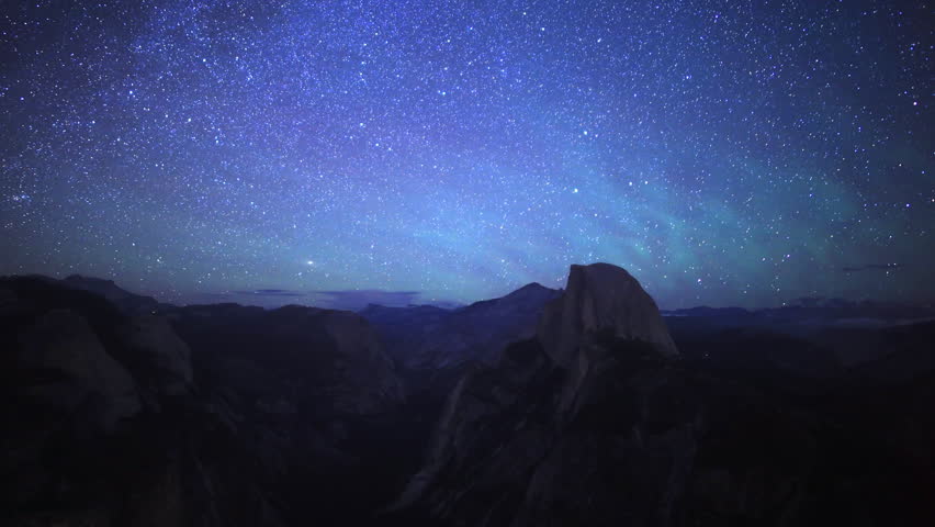 Time-lapse footage with zoom in motion of starry sky and low latitude aurora over Half Dome in Yosemite National Park, California