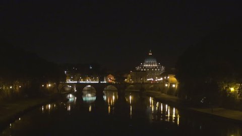 Illuminated Saint Peters cathedral by night, water reflection of River Tiber, Rome panorama