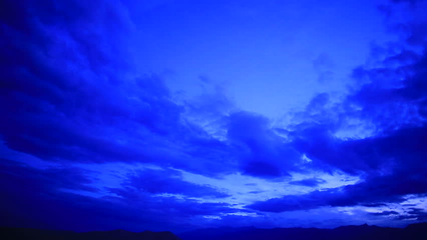 Time-lapse footage of clouds over desert sand dunes at sunrise in Death Valley National Park, California