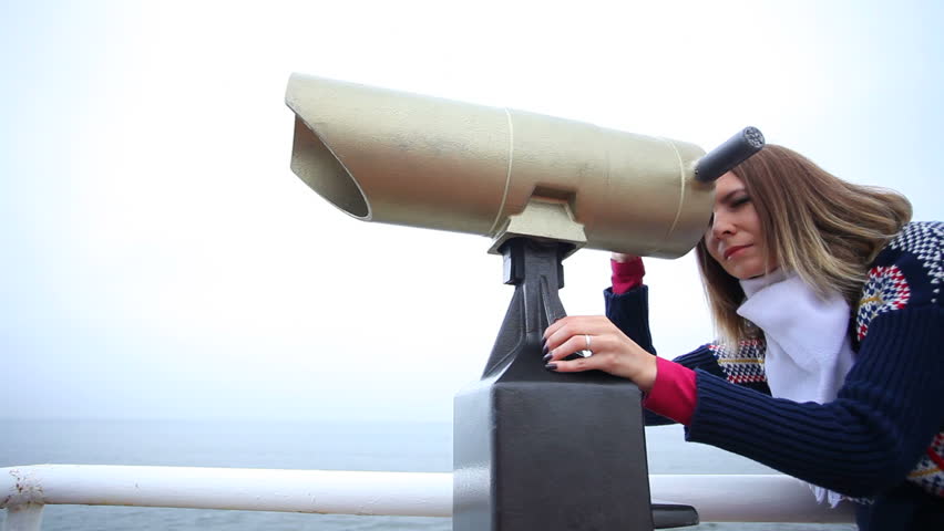 Travel and tourism. Woman looking through the tourist binoculars at the sea or ocean shore. Resort. Full HD with motorized slider. 1080p.