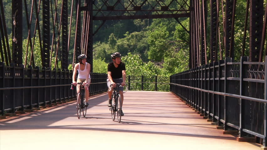 A young couple bike and sightsee on the bike trails on Washington's Landing, an