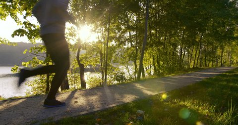 Young man running in park during sun rise – slow motion