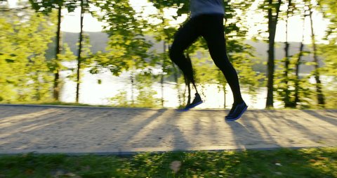 Young man running in park at morning during sun rise – slow motion