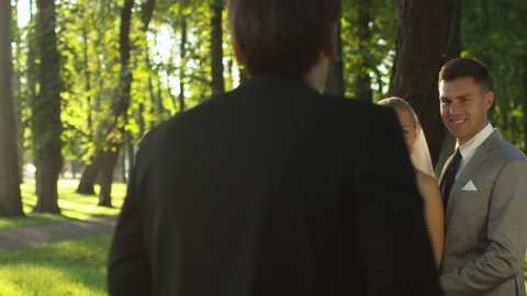 Bride and groom are having a wedding photo session in a sunny park. Shot on RED Cinema Camera in 4K (UHD).の動画素材