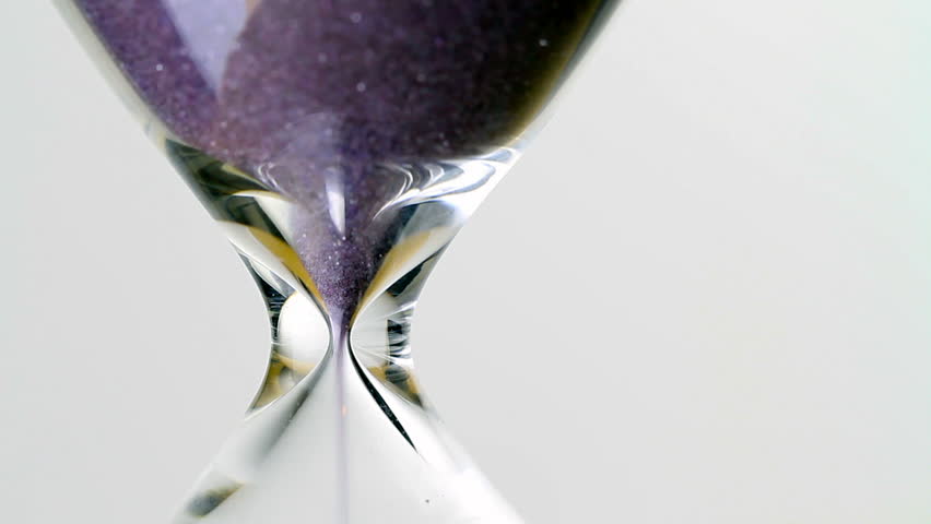 hourglass close up macro, as sand speeds away