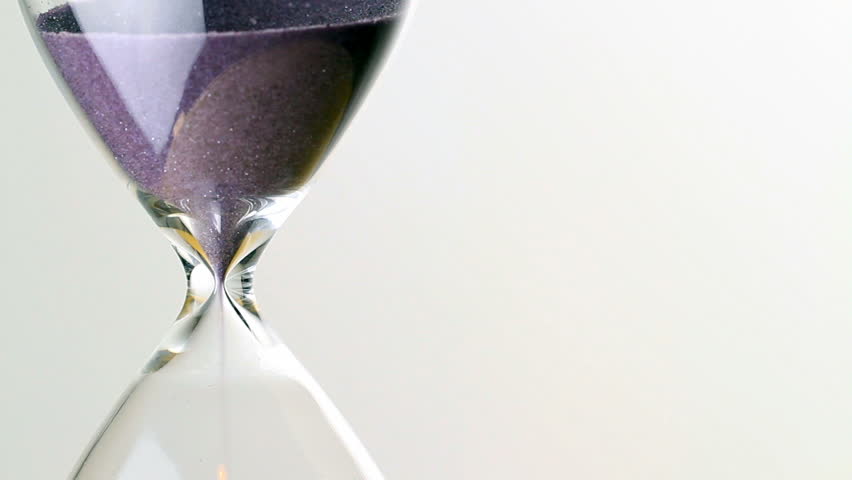 hourglass close up macro, as sand speeds away, further shot