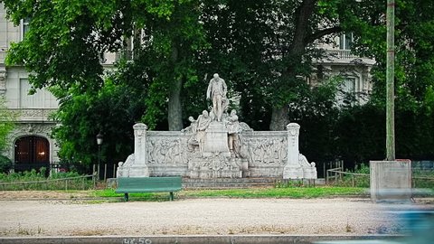 PARIS, FRANCE - JULY 9, 2015: Cars passing in front of the old memorial to Jean-Charles Alphand by Jules Dalou on famous Avenue Foch.
