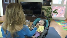 Mother giving food to her adorable child at home. 4K UHD video clip.