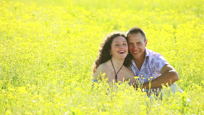 Portrait of happy couple in meadow. Kissing.  