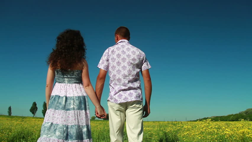 Loving couple walking in field,  