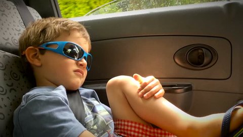 Young boy wearing sunglasses / Toddler wearing sunglasses inside car