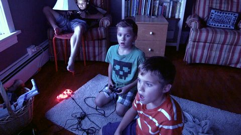 Two Twin Brothers sit in front of a television playing video games