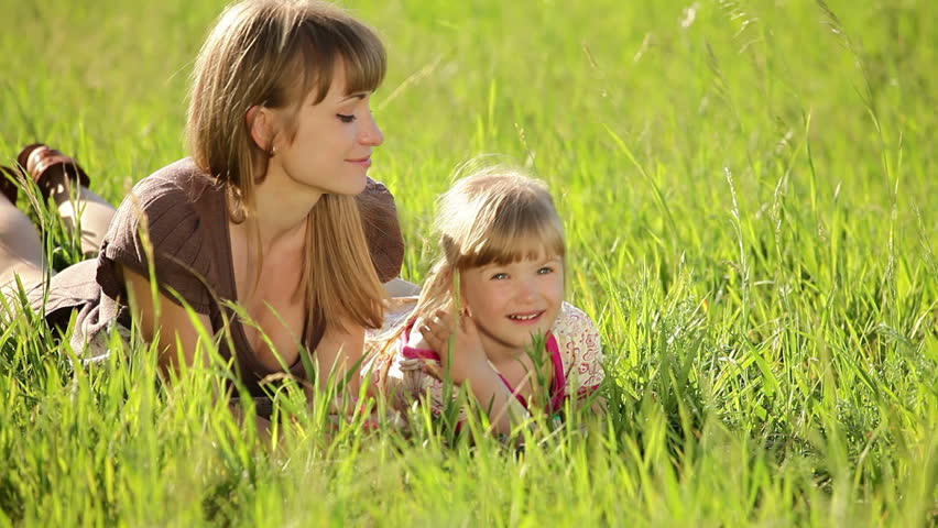 Happy mother and daughter in the grass. Family in  grass 