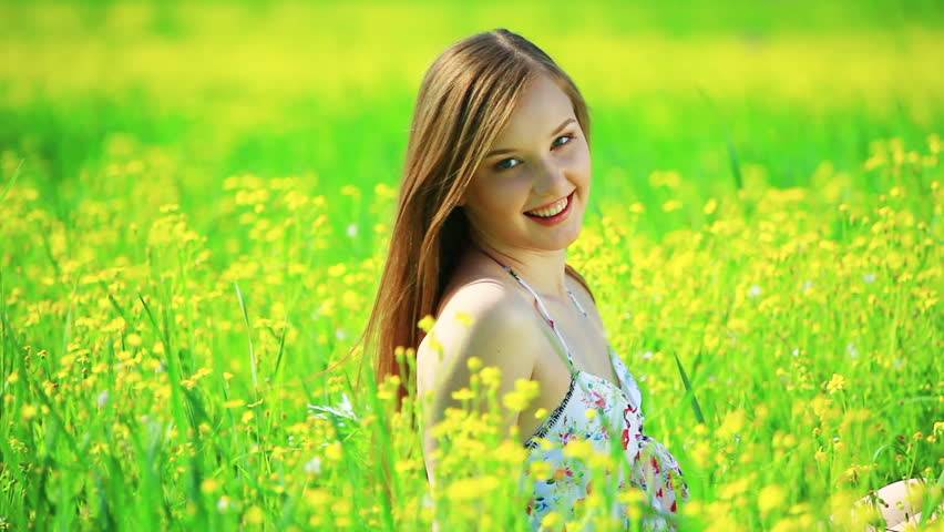 Happy teen on the meadow with yellow flowers. 