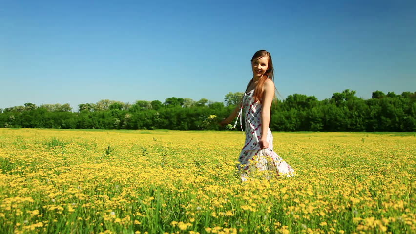 Happy teen spinning in a field of flowers 