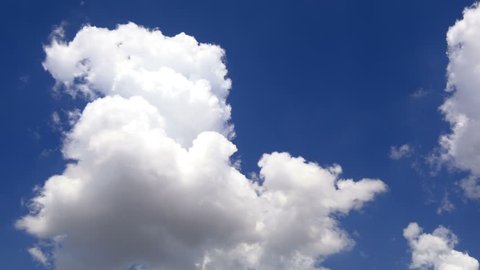 Clouds running across brilliant blue sky. 1 Minute, 30 fps footage of 4K timelapse cloudscape. Cumulus clouds form against a dark blue sky. 4k Timelapse of white clouds with blue sky in background
