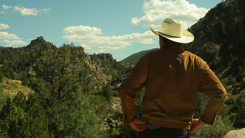 Cowboy looking at land or property.