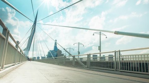 Version 2 of Beautiful Winnipeg Time lapse of pedestrians passing over the iconic Provencher Bridge with the Human Rights Museum in the background on Sunny Day.