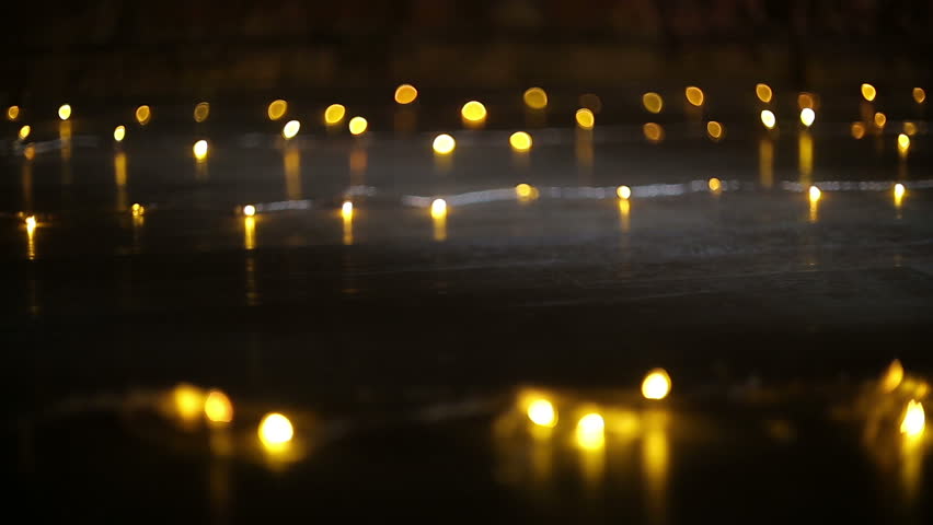 Female feet in black high heel shoes walk on the floor with blurred lights 