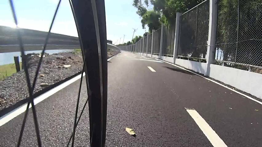 Low angle view shot of riding a bicycle in the park areas. Camera attached to bike. 