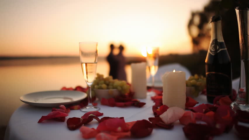 Couple on romantic date at beach restaurant at sunset